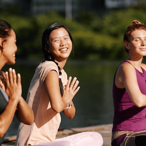 Wellness coach assisting student with yoga
